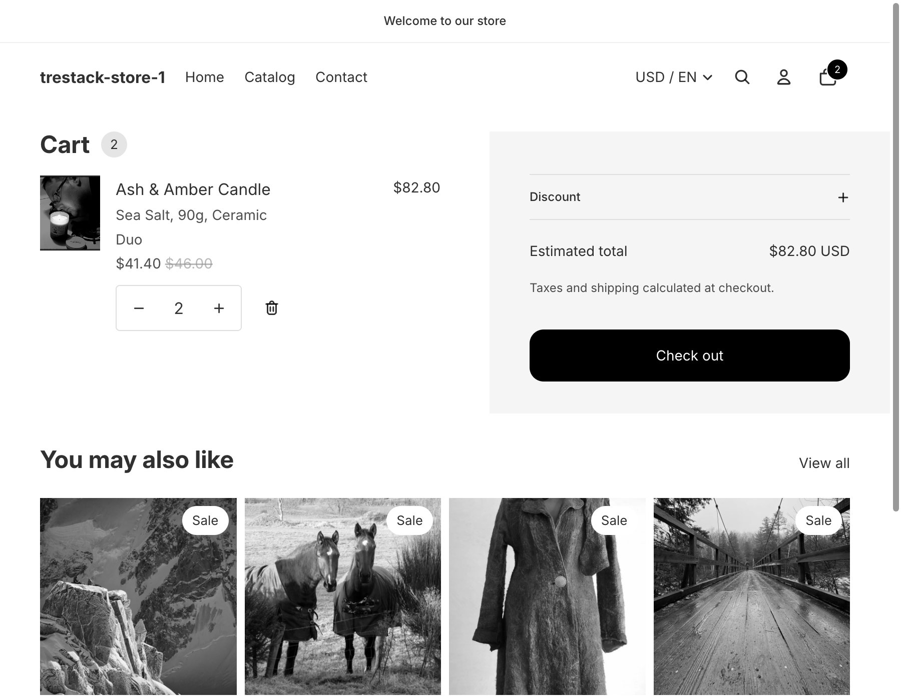A cart page on a development store in grayscale, with two candles at 41.40 dollars each instead of 46 dollars under the offer name Duo, and an estimated total of 82.80 dollars